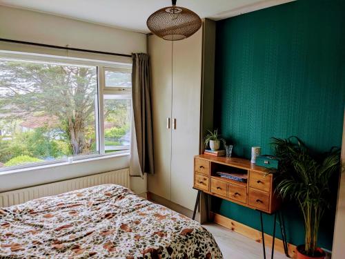 1 dormitorio con pared verde, cama y ventana en Edge of Donard, Full house in Newcastle, en Newcastle
