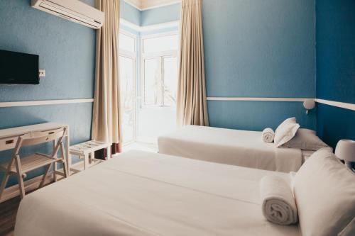 a hotel room with two beds and a window at Hotel Leiria Classic in Leiria