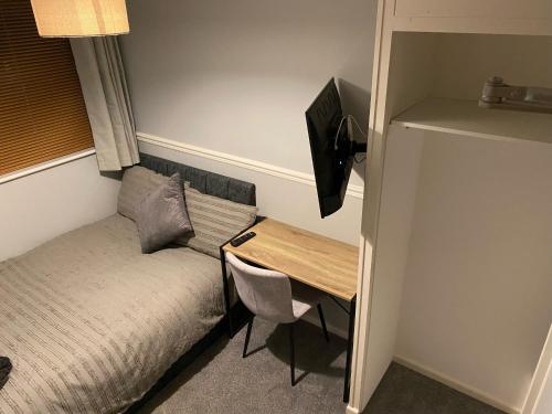 a small room with a bed and a desk at Rosanne's Rest in Stevenage