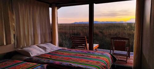 1 dormitorio con cama y ventana con vistas en Alojamiento Lago Titicaca, en Puno