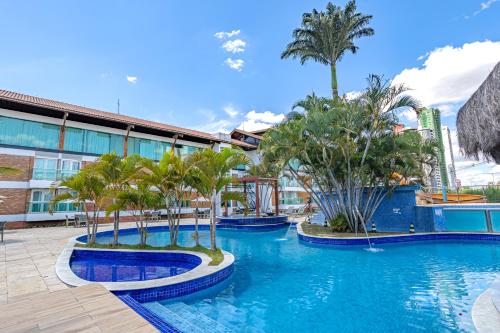 basen w ośrodku z palmami i budynek w obiekcie Hotel Village Premium Campina Grande w mieście Campina Grande