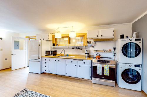 una cucina con elettrodomestici bianchi e mobili bianchi di Mill Creek Retreat a Fort Bragg