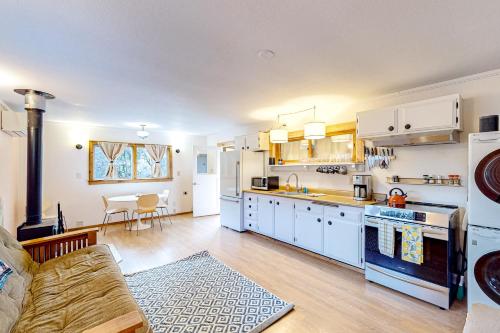 una cucina con mobili bianchi e un soggiorno di Mill Creek Retreat a Fort Bragg