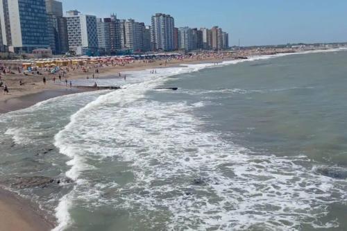 una vista aérea de una playa con personas y edificios en Departamento a 200mts de la playa en Miramar