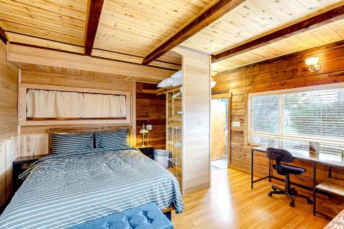 1 dormitorio con cama, escritorio y ventana en Mill Creek Retreat, en Fort Bragg