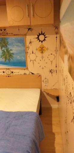 a bedroom with a bed and a window with drawings on the wall at Mobil Home 4Pers VO in Talmont