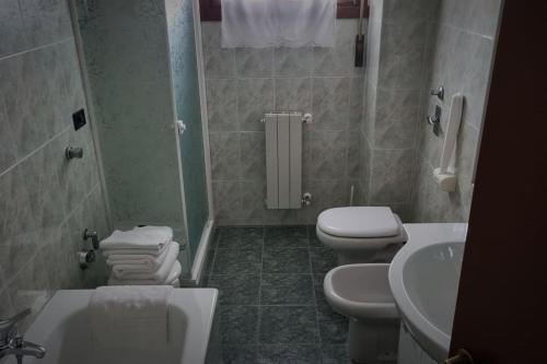 ein Badezimmer mit 2 WCs, einem Waschbecken und einer Badewanne in der Unterkunft Appartamento Vista Panoramica in Agrate Brianza