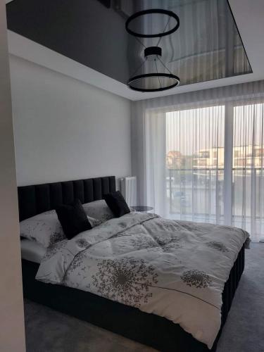 a bedroom with a bed and a large window at Westin House Black in Kołobrzeg