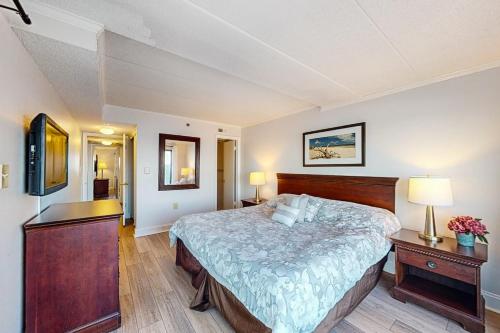 a bedroom with a bed and a desk with two lamps at Marigot Beach 510 in Ocean City