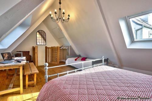 a bedroom with a bed and a desk and a window at Gîte chaleureux à 3km des plages in Guimaëc