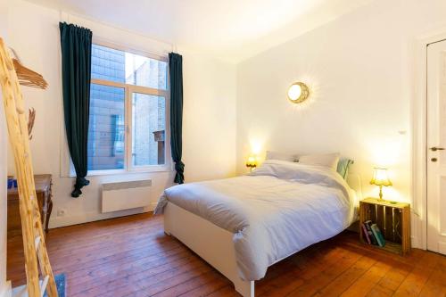 um quarto com uma cama branca e uma janela em Green Oasis in the city em Antuérpia