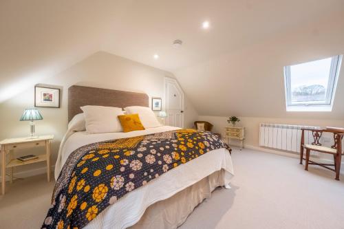 a bedroom with a large bed and a window at Dedham Vale Cottage with Swimming Pool - Yew Tree Barn in Higham