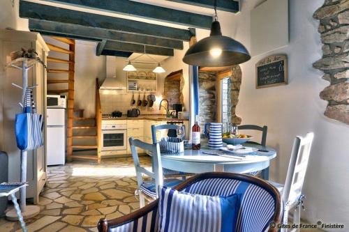a kitchen with a table and chairs in a room at Gîte chaleureux à 3km des plages in Guimaëc