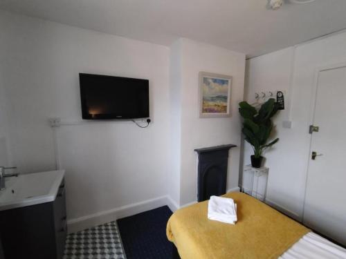 a room with a bed and a tv on the wall at The Crown Inn - By Whitney Inns in Keynsham