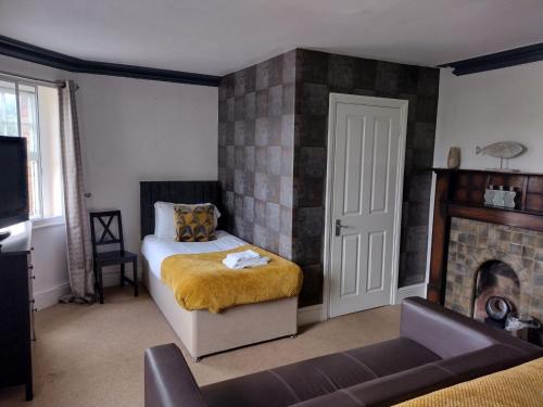 a bedroom with a bed and a fireplace at The Crown Inn - By Whitney Inns in Keynsham