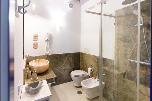 een badkamer met een douche, een toilet en een wastafel bij Casa Cuore di Nonna in Savelletri di Fasano