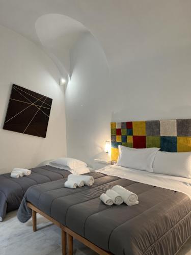 two beds in a room with towels on them at Rossaroll Holiday Houses in Noto