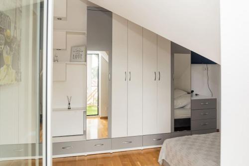 Schlafzimmer mit weißen Schränken und einem Bett in der Unterkunft Apartament na Górnej in Puńsk