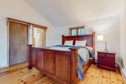 una camera con un grande letto in legno e un pavimento in legno di Bomo Hacienda a Castleton