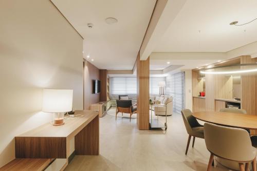 a living room with a table and chairs at Mercure Curitiba Batel in Curitiba
