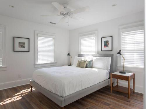 a white bedroom with a bed and a ceiling fan at Solarium at Cassa Zoe in Charleston