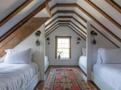 um quarto no sótão com 2 camas e uma janela em Sparrow at Casa Zoe em Charleston