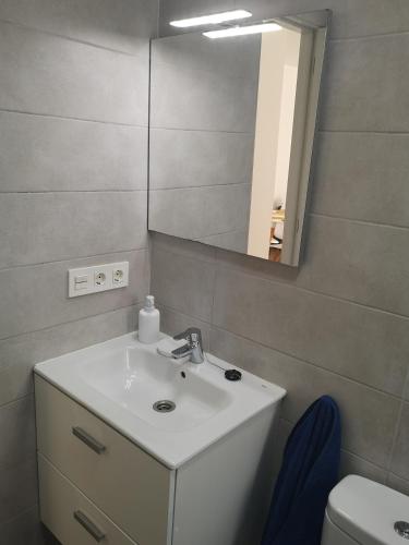 a bathroom with a sink and a mirror at Casa Merlín Arena in Playa Honda