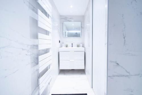 une salle de bain blanche avec un lavabo et un miroir dans l'établissement Villa in paris - Eiffel Tower area, à Paris
