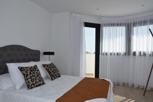 Ένα ή περισσότερα κρεβάτια σε δωμάτιο στο PANORAMISCH modern vakantiehuis in Finestrat bij Benidorm met 3 slaapkamers, gelegen op de 1ste lijn met privézwembad en omheinde privétuin, zicht op zee, de bergen met 'Kilómetro Vertical del Puig Campana' en op de skyline van Benidorm City en Finestrat