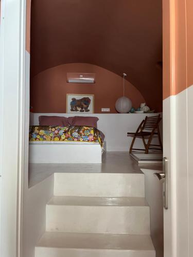 a bedroom with stairs leading to a bunk bed at IANUA Casa per Viaggiatori in Astypalaia