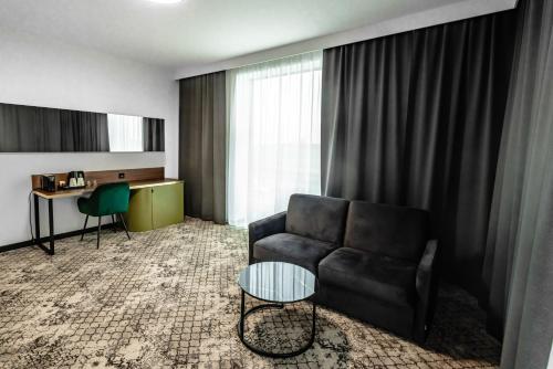 een woonkamer met een bank en een tafel bij Restoria Hotel*** in Radzyń Podlaski