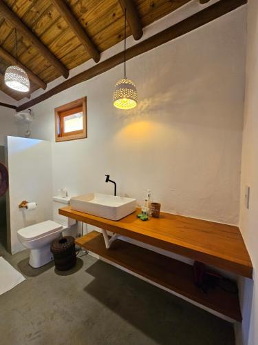 a bathroom with a sink and a toilet at Tawa Caraíva in Caraíva