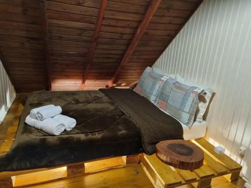 ein Bett im Dachgeschoss mit Handtüchern drauf in der Unterkunft Chalé Villa das Hortênsias in Annitapolis