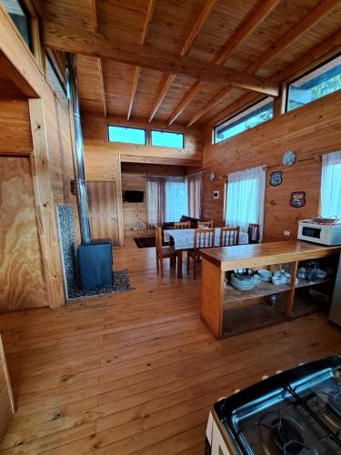 a kitchen and dining room with a stove in a cabin at Cabañas M&R Lago Ranco in Lago Ranco