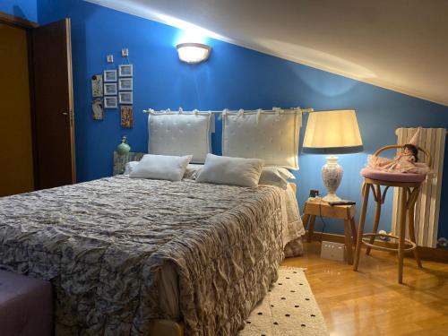 1 dormitorio con 1 cama con pared azul en Soggiorno da Fiore, en Monte Rubiaglio