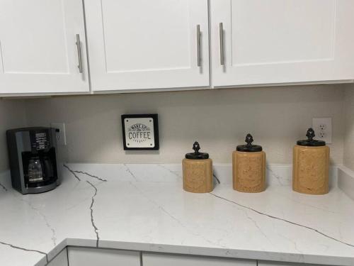 three bottles on a kitchen counter with a microwave at Minutes to Fairgrounds, Hard Rock, & Busch Gardens in Tampa