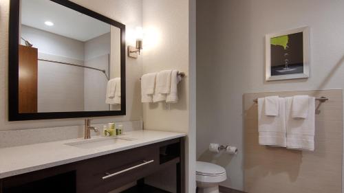 a bathroom with a sink and a toilet and a mirror at Best Western Plus College Station Inn & Suites in College Station