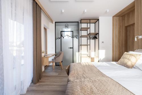 a bedroom with a bed and a desk at Apartamenty Krokusowa Dolina in Kościelisko
