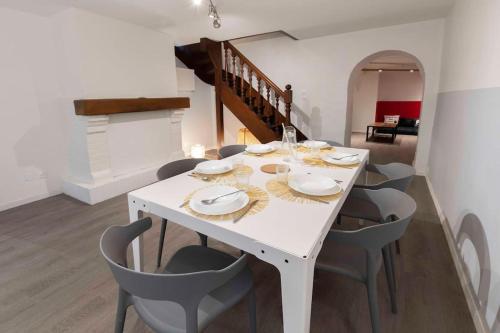 een witte eettafel met stoelen en een witte eetkamer bij L'ÉCHAPPÉE BELLE Maison à 10 min du cœur de Rouen in Amfreville-la-Mi-Voie