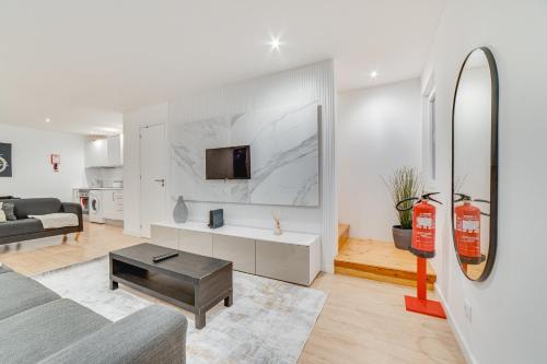 a living room with a couch and a tv on a wall at Duplex Apartment near Belém in Lisbon