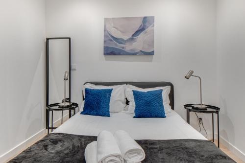 ein Schlafzimmer mit einem großen Bett mit blauen Kissen in der Unterkunft Duplex Apartment near Belém in Lissabon