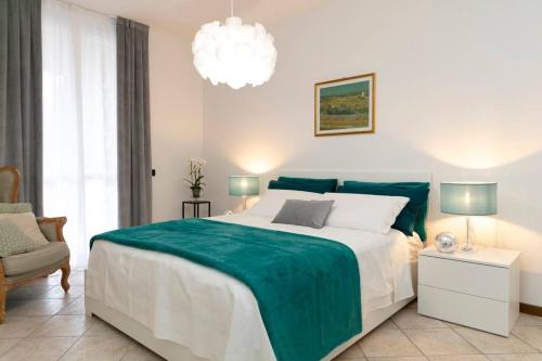 a bedroom with a large bed and a chandelier at La piazzetta in Vedano Olona