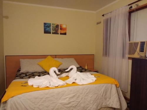 Dos cisnes hechos de toallas en una cama en Departamento en Nueva Córdoba en Córdoba