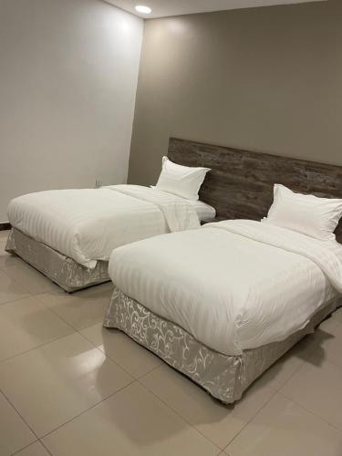 2 Betten nebeneinander in einem Zimmer in der Unterkunft دار المسك in Dammam