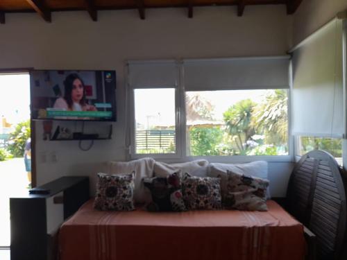 - une chambre avec un lit et une télévision murale dans l'établissement Cabaña Marilau monoamb, à Camet Norte