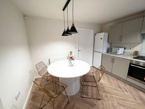 a kitchen with a white table and chairs in a room at Beautiful 3-Bed House in Bradford in Bradford