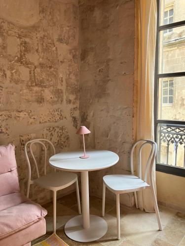 - une table avec deux chaises et une lampe rose dans l'établissement Pop'Arles, à Arles