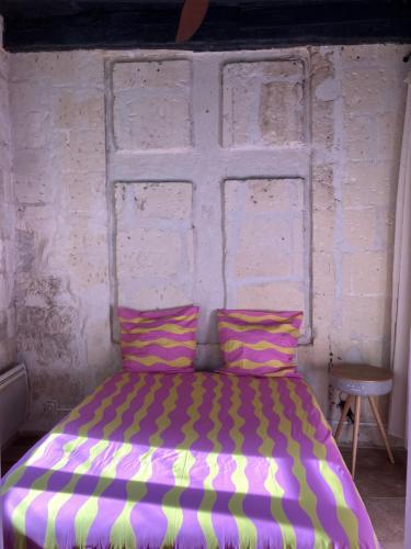 a bed in a room with a brick wall at Pop'Arles in Arles