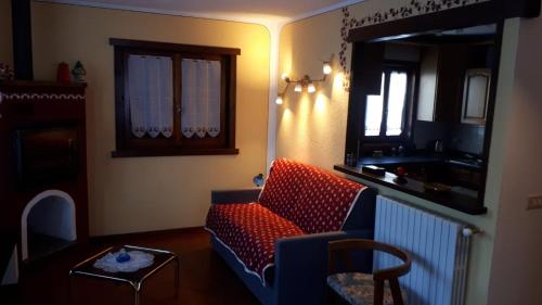 a living room with a red couch and a mirror at Bilocale Piano Terra Villetta - La Thuile Frazione Buic in La Thuile