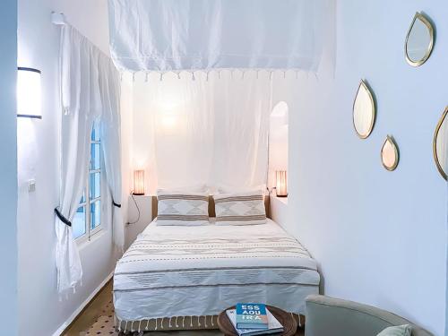 a small bedroom with a bed and a window at Riad Lyon-Mogador in Essaouira